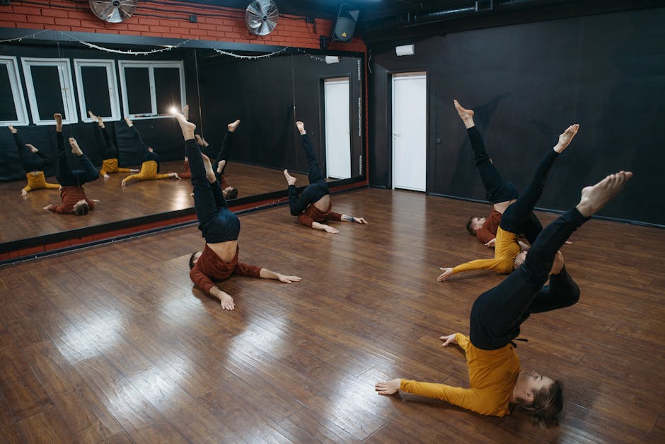 A group of dancers practicing basic dance steps in a spacious studio with mirrors.