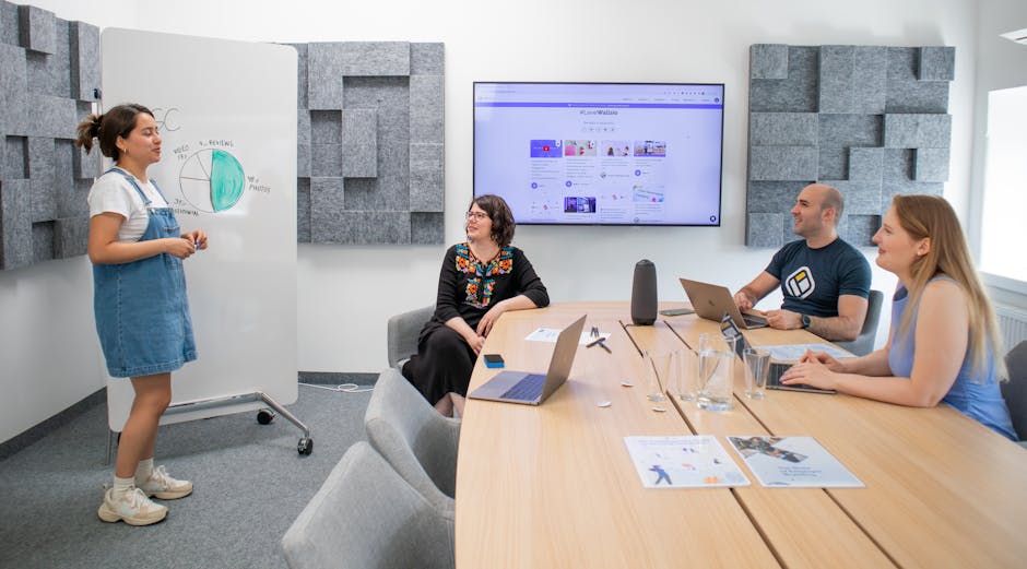 Diverse team brainstorming in a futuristic office with digital marketing analytics displayed on a large screen.