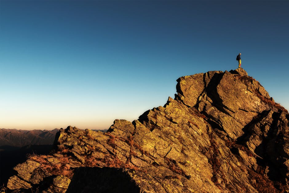 A determined woman climbing a rocky mountain path, symbolizing resilience and the journey to success.